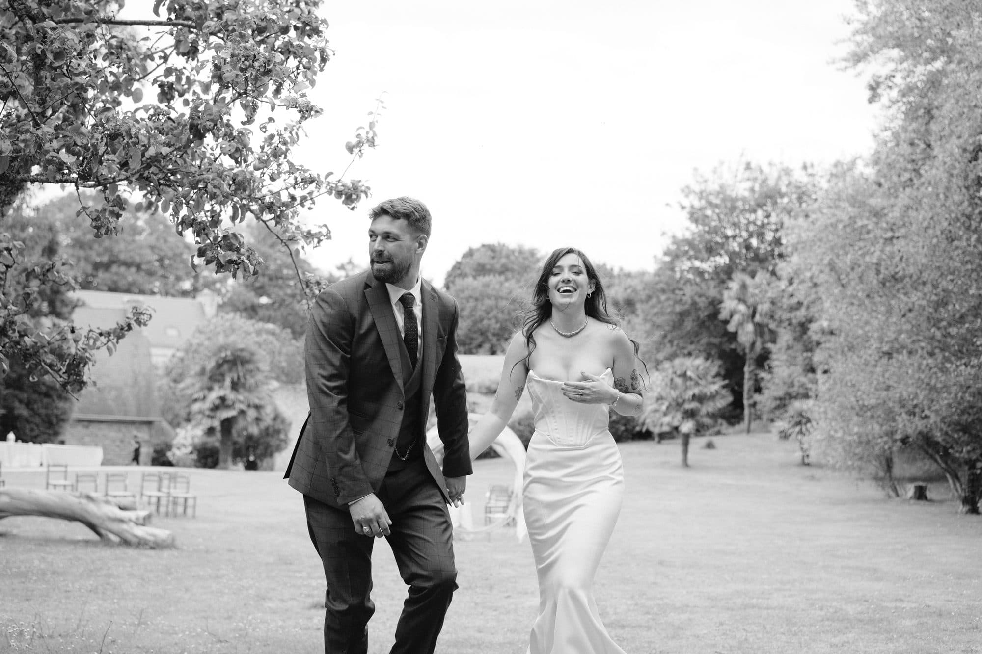 Mariage — les mariés, complices, en marche dans le parc